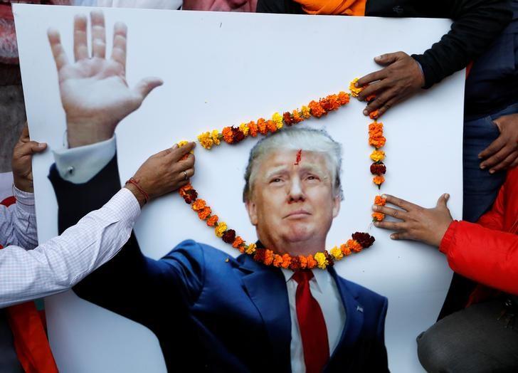 Members of Hindu Sena, a right-wing Hindu group, place a garland on an poster of U.S President-elect Donald Trump ahead of his inauguration, in New Delhi, January 19, 2017. REUTERS/Cathal McNaughton/Files